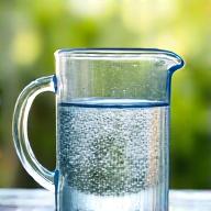 Glass pitcher of clear, filtered water, symbolizing clean water for plants.